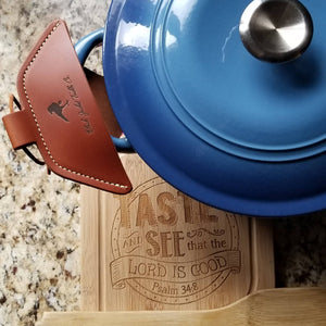 A brown leather cast iron assist handle holder on a Dutch oven