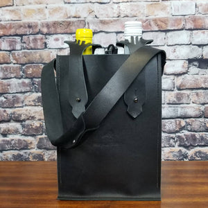 A wine bottle bag for two wine bottles in black leather with gunmetal bottle strap hardware