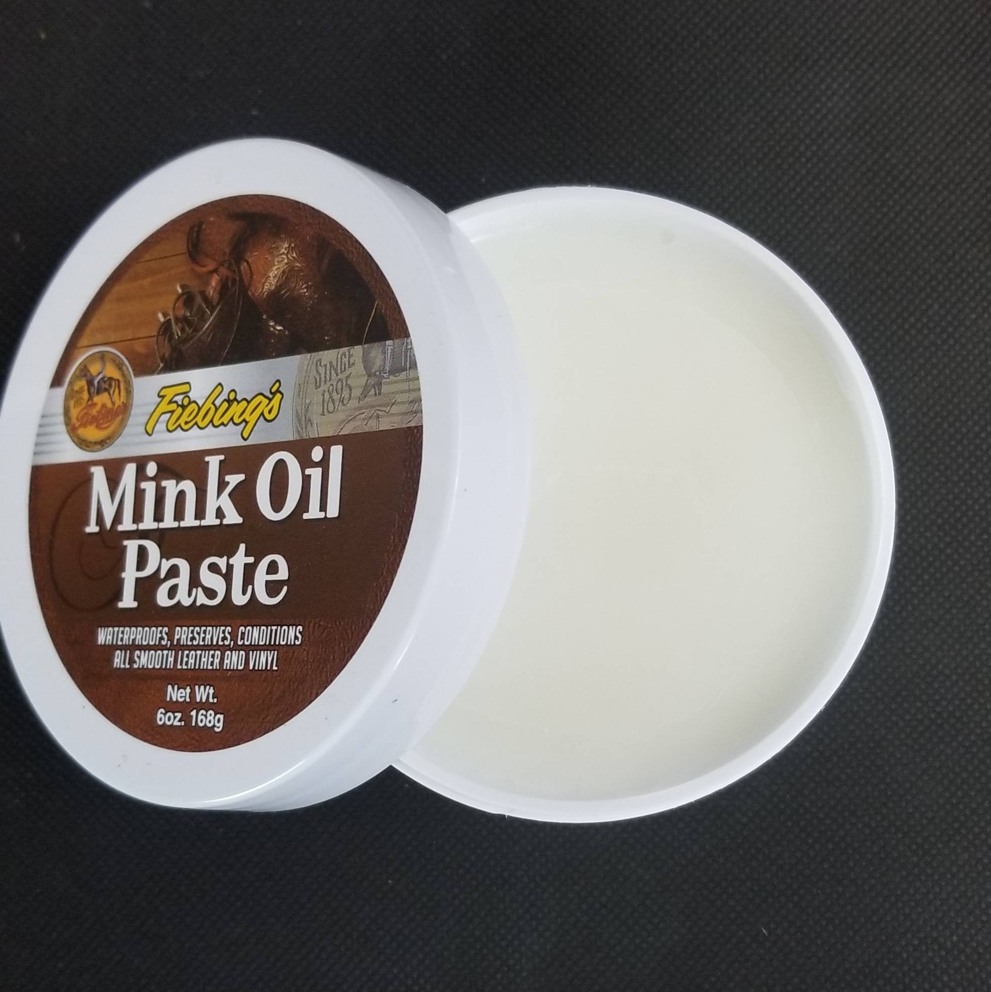 Open tub of Fiebing's mink oil paste shows white paste